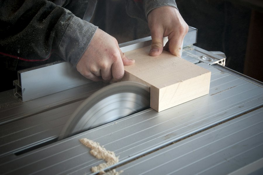 A board being cut to size on a table saw